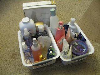 2 small plastic baskets filled with perfumes, lotions and powders