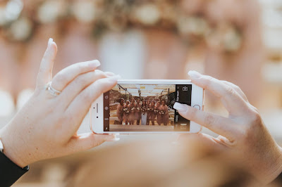 Invitada tomando una foto a la novia y a las damas de honor con su móvil