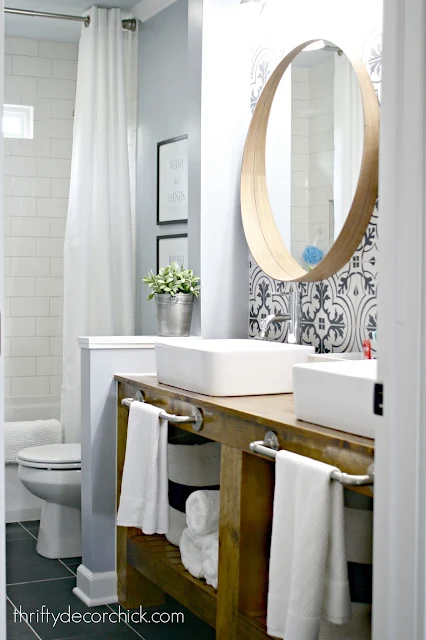 Bathroom makeover with wood vanity and round mirrors