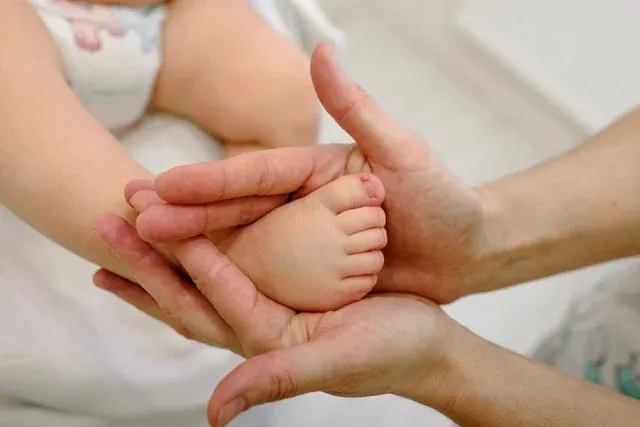 A mother holding baby's foot