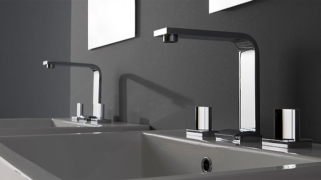 Close up of double vanity with integrated sinks and modern faucets.