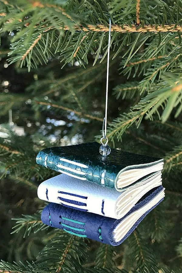tree ornament of three stacked leather handbound books displayed on tree