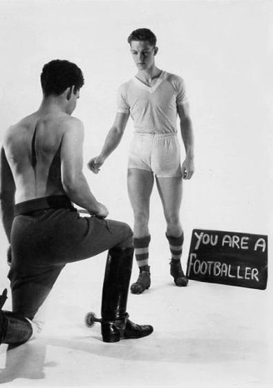 Royale Studio image of Peter George dressed as a footballer in tight shorts, facing a Hussar Guardsman on one knee in breeches, boots and spurs probably Tom Harding.