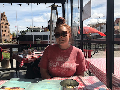 me sitting at a table in a red t shirt with the canal behind me