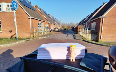 Angel voor een stapeltje brieven met op de achtergrond een straatje