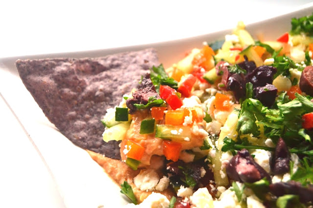 This Mediterranean layered dip features hummus, feta, olives and is loaded with diced vegetables. A quick and flavorful appetizer that no one will know only took you 10 minutes to make! www.nutritionistreviews.com