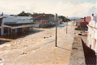 Brown flood waters on Otautau's Main Street, BNZ and drapery buildings