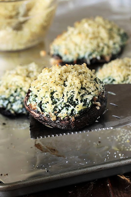 Lifting a Grilled Spinach Dip-Stuffed Portabella Mushroom Cap with a Spatula Image