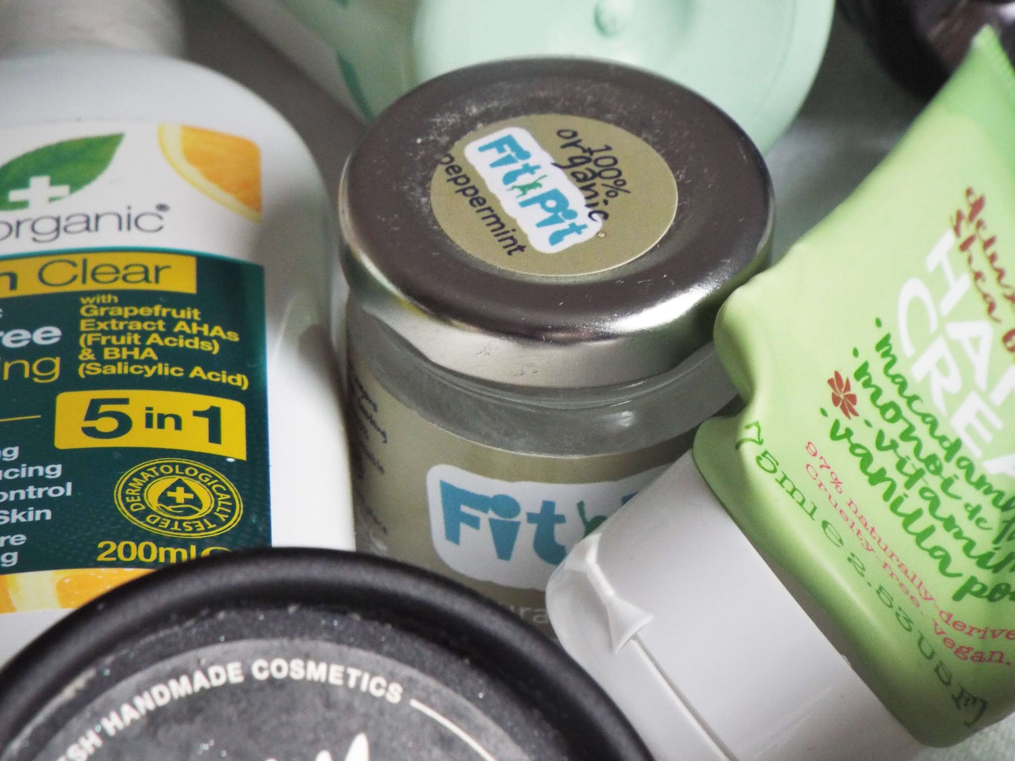 Fit Pit Natural Deodorant Peppermint, nestled amongst other beauty empties. Glass jar, with metal/ tin screw on lid.