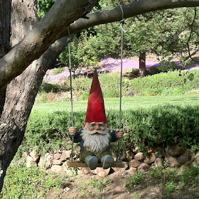 Picture of a gnome riding on a swing in a tree