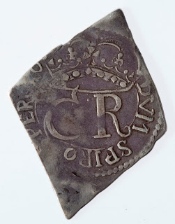 Reverse of the diamond-shaped siege coin with Charles I's royal cipher roughly stamped on the back. Part of it is cut off when the coin was cut,