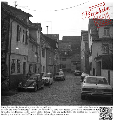 BIAB_Stadtarchiv_Bensheim_Hasenviertel_019.jpg; Stadtarchiv Bensheim; Blick in die Mittlere Hasengasse von Ost nach West, Ecke Hasengasse (Elefant als Werbeschild der Firma Brestel, Hasengasse 8) in den 1970er Jahren, Foto von Willy Helm. EIn Großteil der Häuser im Vordergrund sind in den 1970er und 1980er Jahre abgerissen worden.