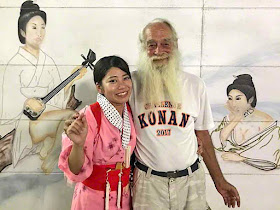 Ryukyu Mike and granddaughter in front of wall art