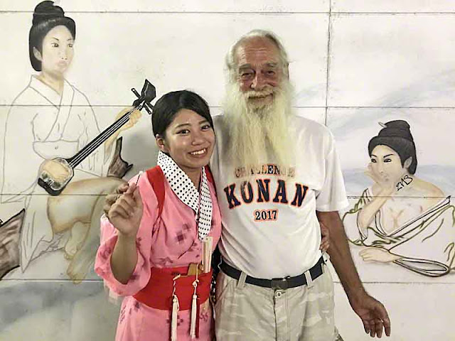 Ryukyu Mike and granddaughter in front of wall art