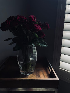 An image of a vase and roses
