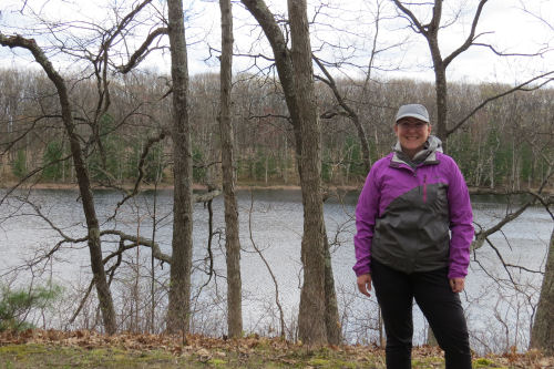 hiker standing with lake in background