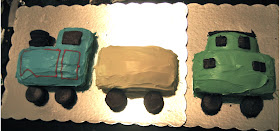 This shows all three cakes in the train cake lined up on two cake boards which are overlapped so they sort of look like one board.