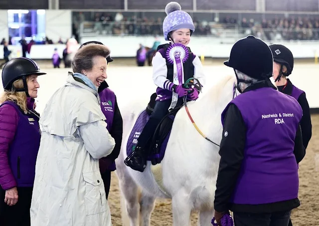 The Princess Royal wore a white trench coat, gold brooch at Reaseheath Equestrian College