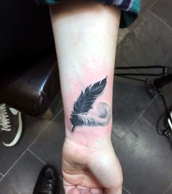 Awesome wrist tattoo ideas black and white feather tattoo design for guy's on the wrist