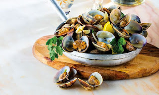 Clams cooked in garlic and white wine sauce, garnished with fresh cilantro