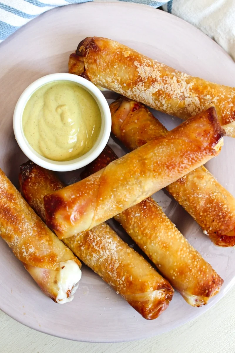 Salami and Cheese Egg Rolls cooked in your air fryer have a crispy egg roll wrapper shell filled with melty mozzarella cheese wrapped in Genoa salami. Dip them in mustard or marinara! #eggrolls #appetizer #mozzarellasticks