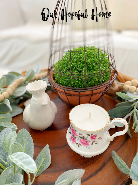 delicate petit rose tea cup candle crowned porcelain bird greenery in a rattan tray