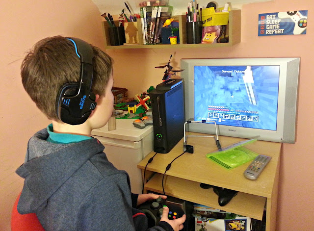 Boy wearing headset, playing game on Xbox 360
