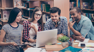 4 people gathered around laptop image