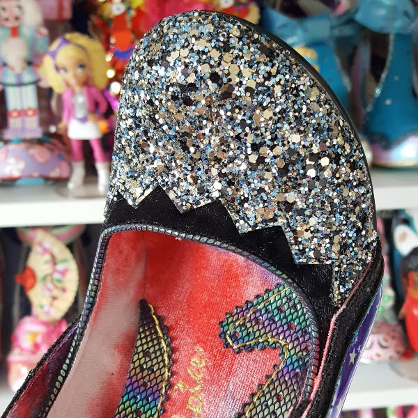 close up of silver glitter toe of court shoes with shoe room in background