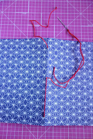 self-healing mat, scrapbook paper, needle, thread