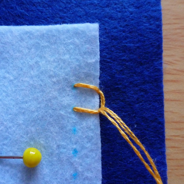 First blanket stitch formed on felt applique square