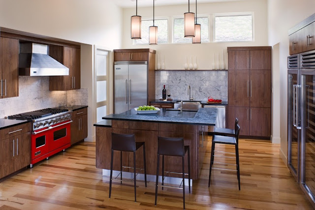 Photo of modern kitchen interiors with dark brown furniture and red oven
