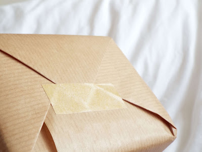 Tilted box showing the brown paper tape securing the wrapping paper together.