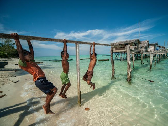 Ng Choo Kia - Crianças Bajau brincam em ponte simples feita de uma unica taboa sobre o mar