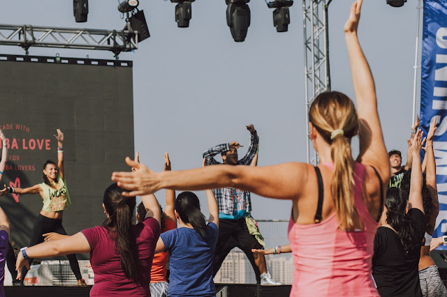 a-woman-in-pink-tank-top-raising-her-hands