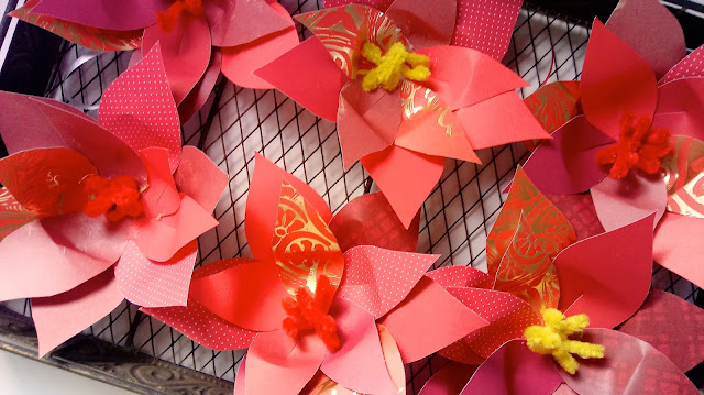 pretty red paper poinsettias sitting in a basket