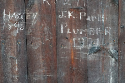 Graffiti on wood saying 'Harvey 1895' and JK Paris, Plumber, 1971