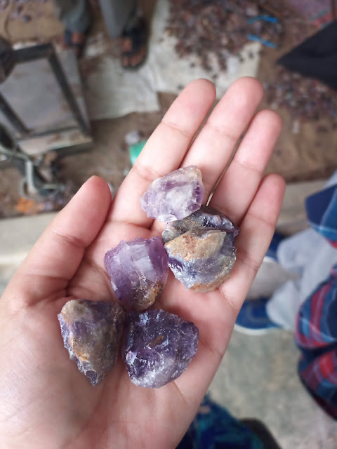 Pieces of raw amethyst held in a hand