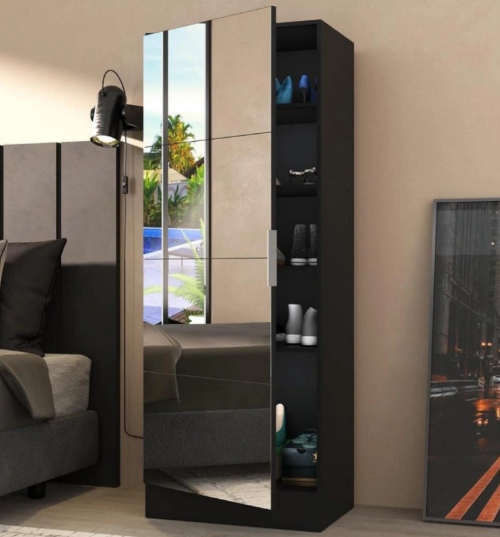 Quarto bege, tem uma sapateira preta com a porta com espelho entreaberta.