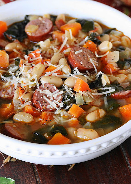 Close-Up of White Bean & Kielbasa Soup with Spinach Topped with Parmesan Image