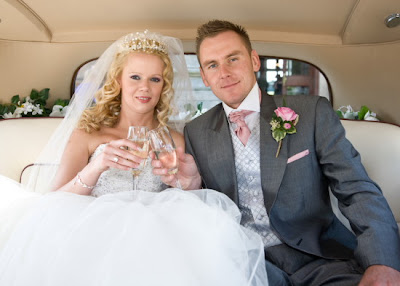 Newly weds have champagne in Rolls Royce
