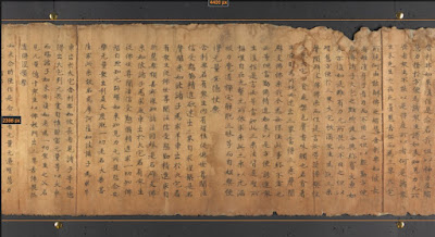 Close view of yellowed scroll with Chinese characters on it with black bars above and below.