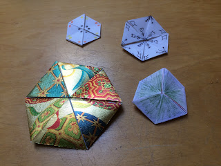 Hexahexaflexagons, one made of shiny wrapping paper