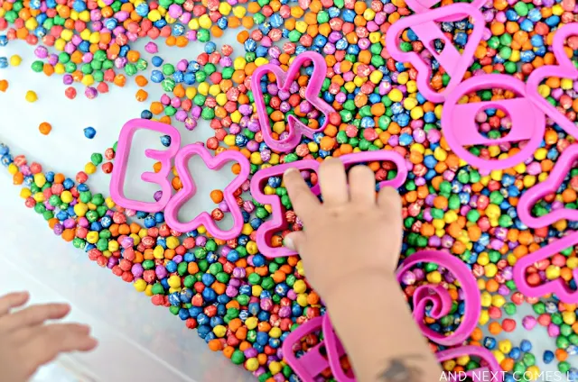 Spelling words with this simple sensory bin using rainbow dyed chickpeas from And Next Comes L