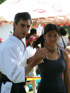 Picture of a volunteer learning how to relax positivley without collapsing during a demonstration at a summer festival.