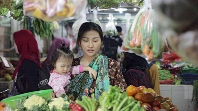 Gaya Sarwendah saat berbelanja di pasar tradisional sambil menggendong anak. [Instagram]