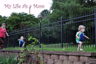 Mom chasing two toddlers on a wall.