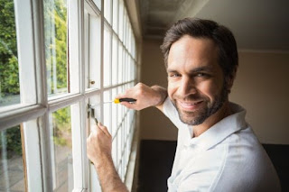 Window installer tightening the screws of the window