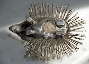 He's a solid silver hallmarked pincushion in the shape of a hedgehog. (hedgehog pincushion )