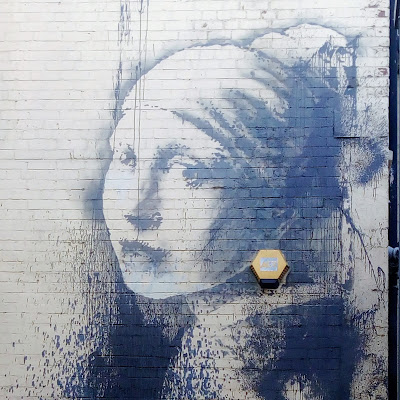 Banksy artwork, featuring a woman in the style of the girl with the pearl earring. 